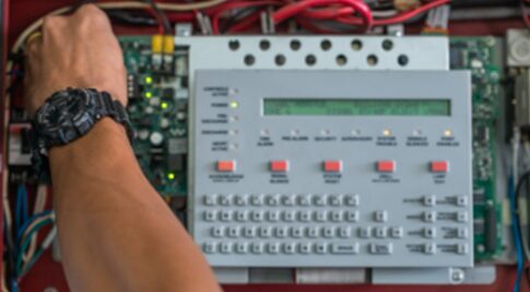 A person is standing next to an electronic device.